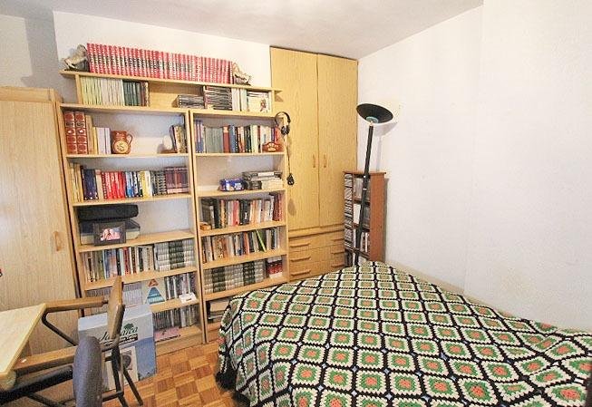 Habitación con estantería y cama
