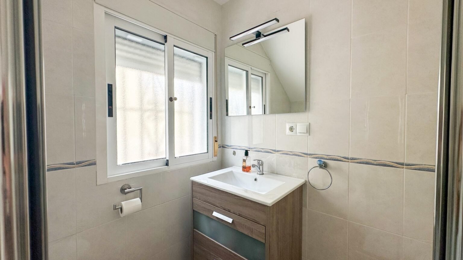 Baño moderno con lavabo y espejo