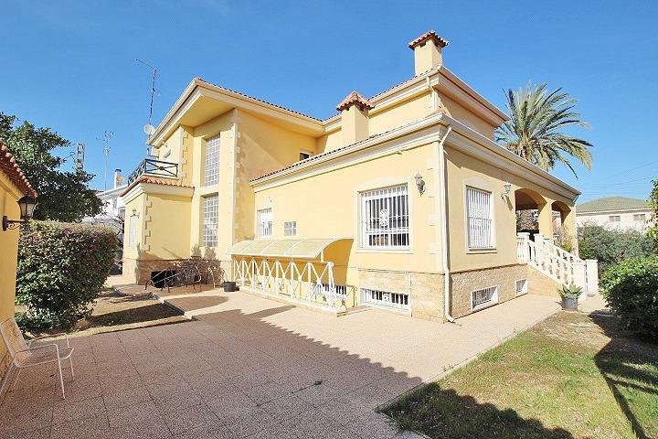 Casa amarilla con jardín