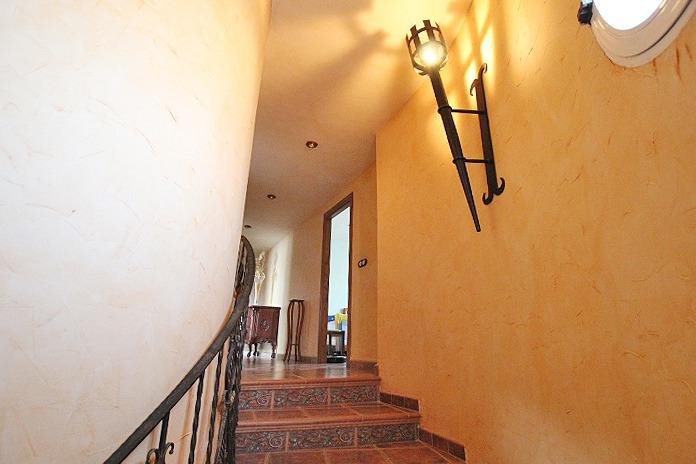 Pasillo con escaleras y luz cálida