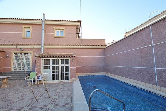 Casa con piscina en un patio