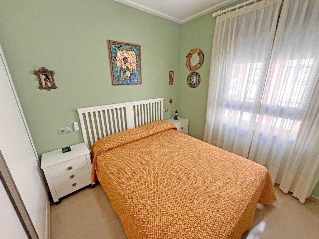 Habitación con cama individual y paredes verdes