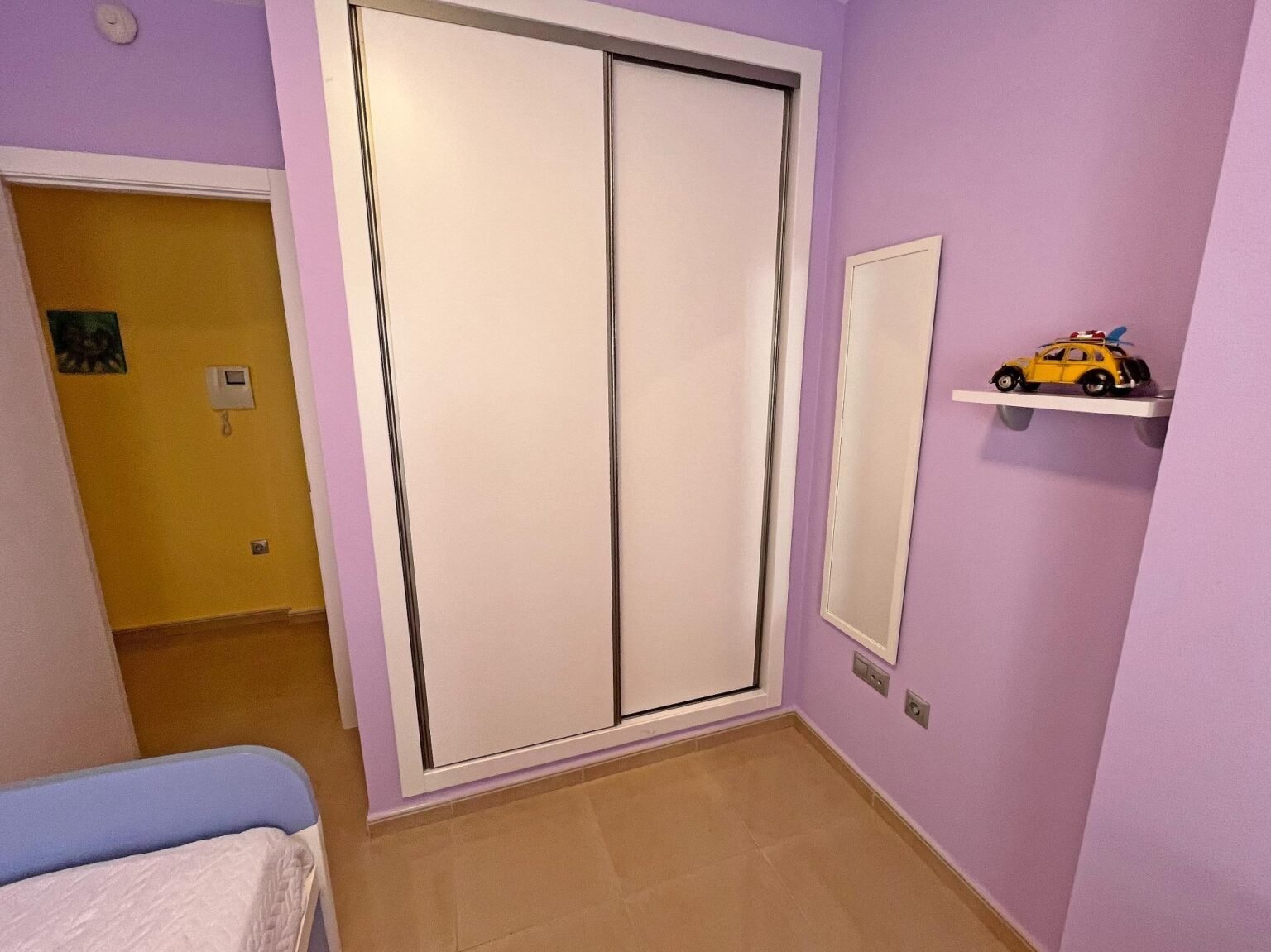 Habitación con paredes moradas y armario