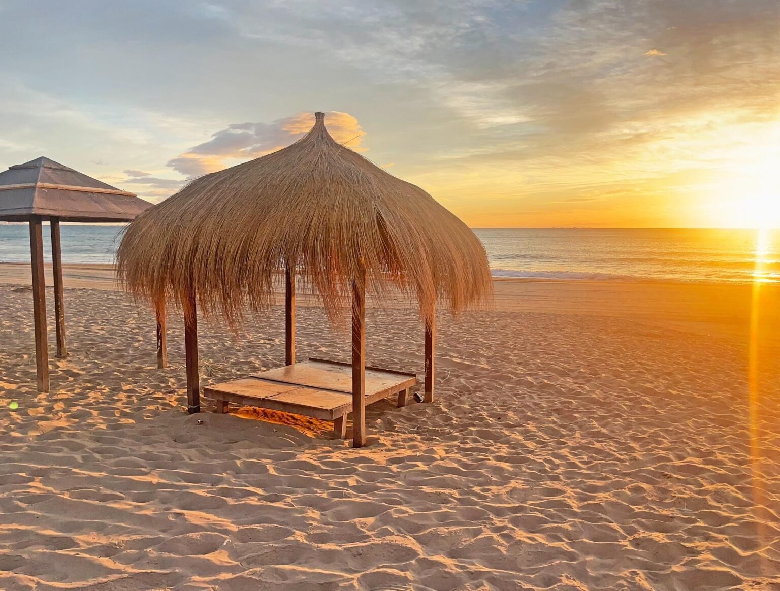 Atardecer en la playa con palapa