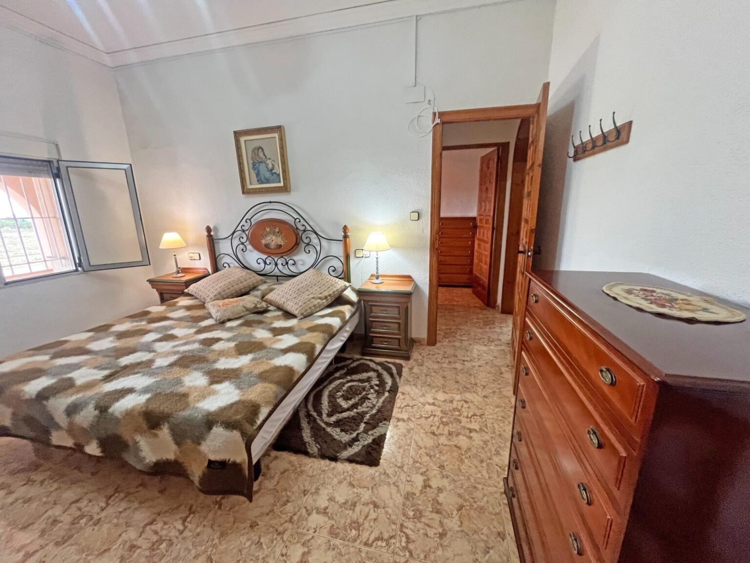 Habitación con cama y muebles de madera