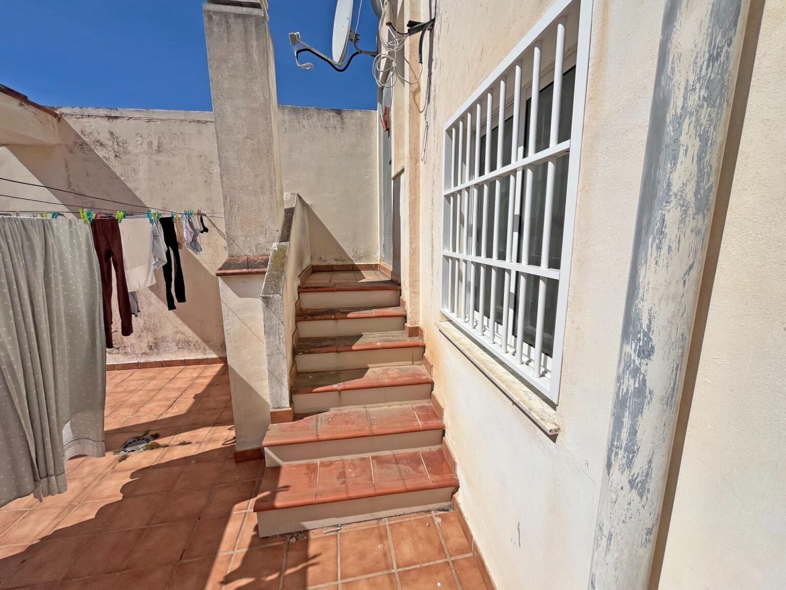 Escalera en patio con ropa tendida
