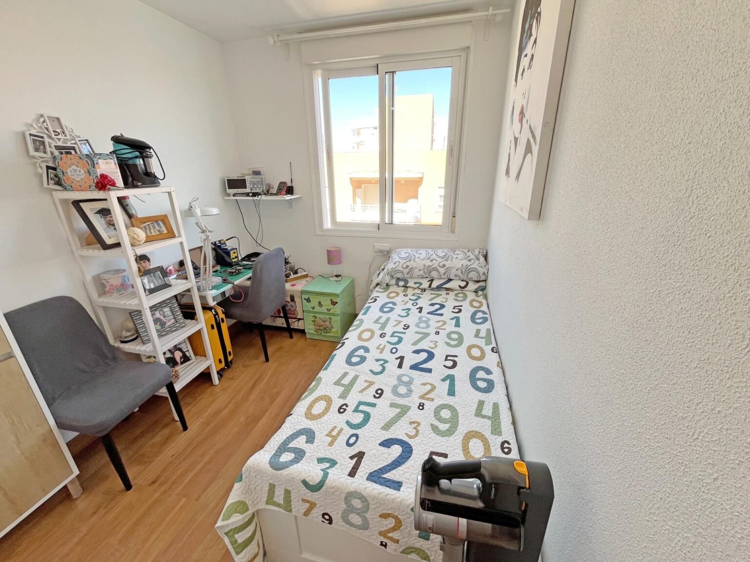 Habitación pequeña con cama y escritorio