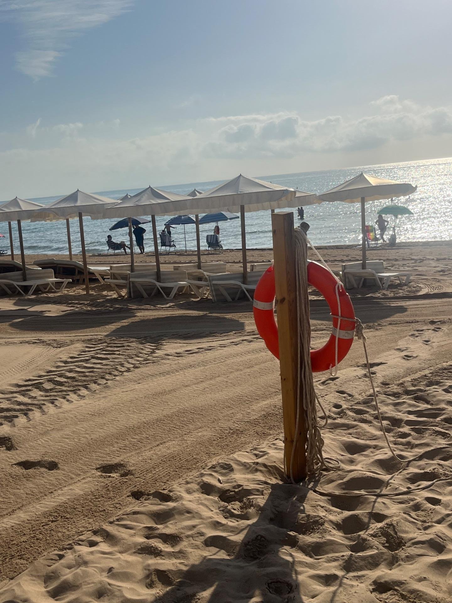 Playa con sombrillas y salvavidas