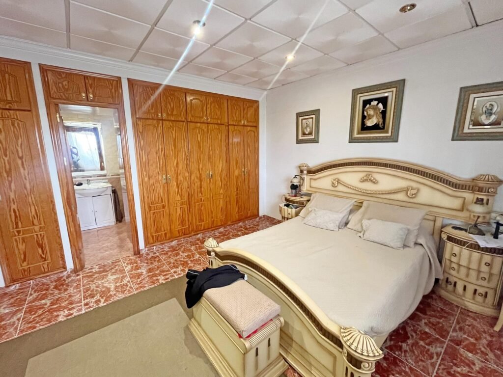 Habitación con cama matrimonial y muebles de madera clara
