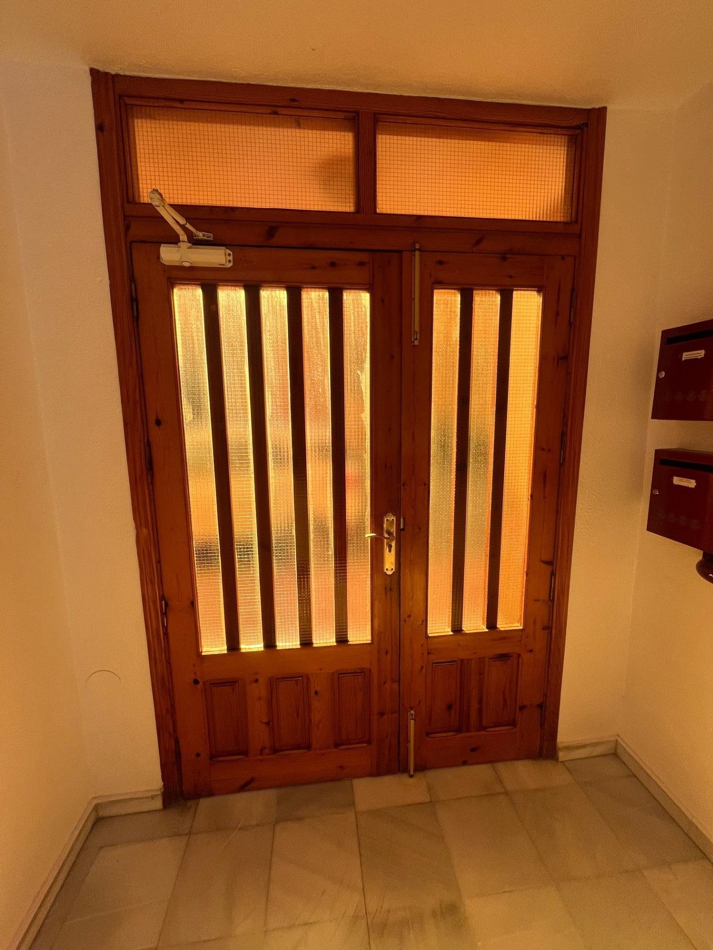 Puerta de madera con paneles de cristal
