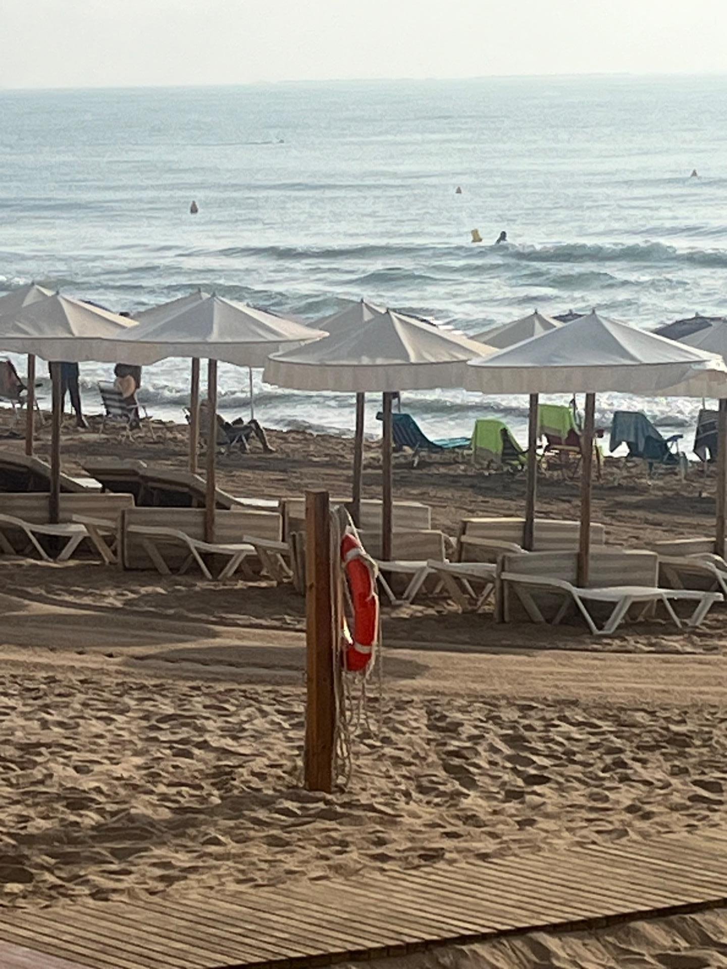 Playa con sombrillas y salvavidas