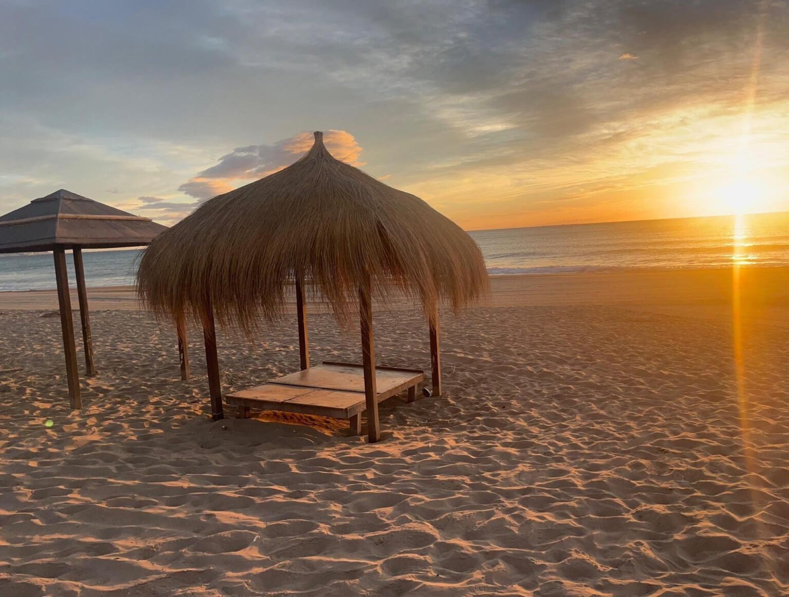 Atardecer en la playa con palapas