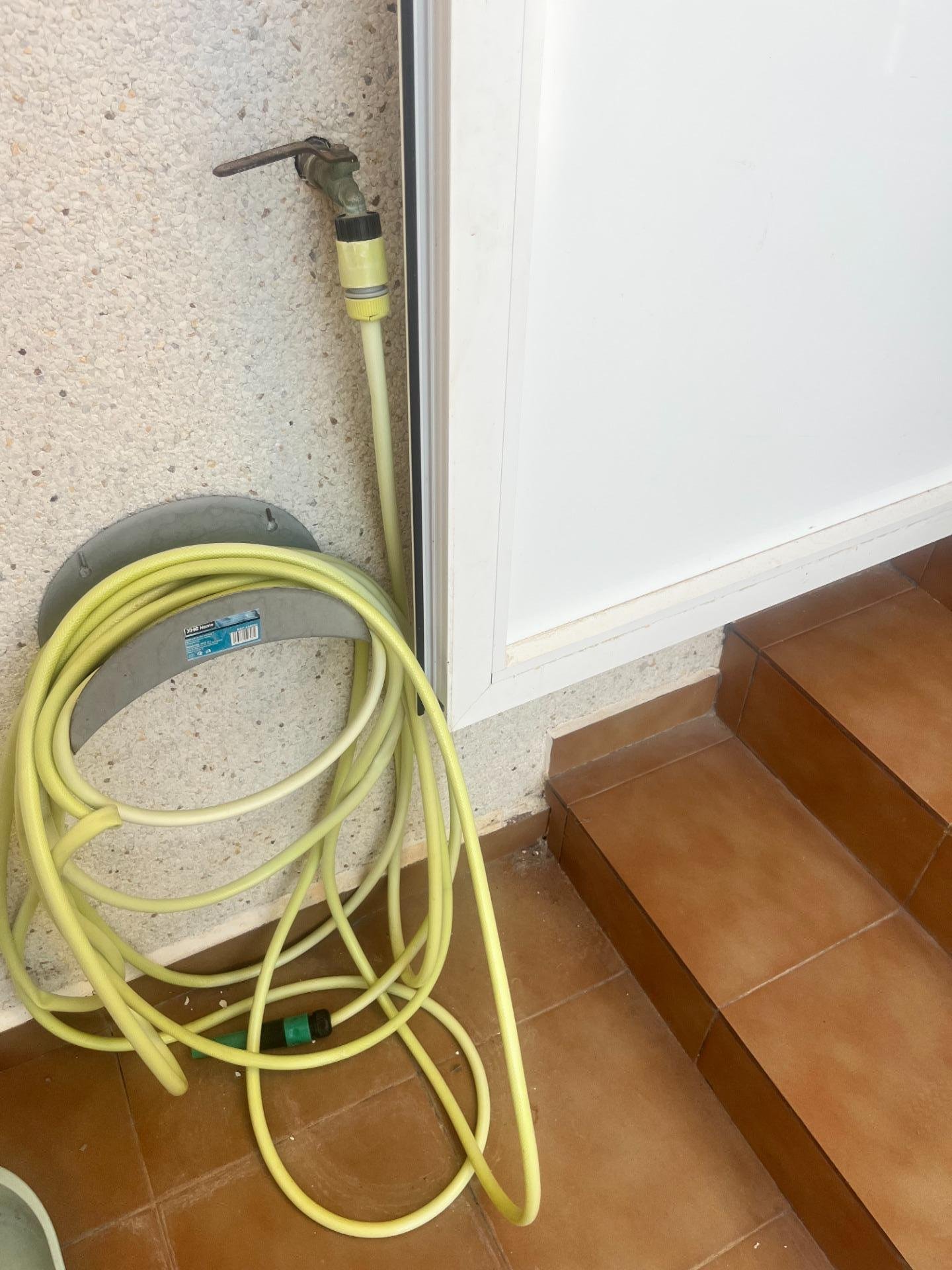 Manguera amarilla en la pared