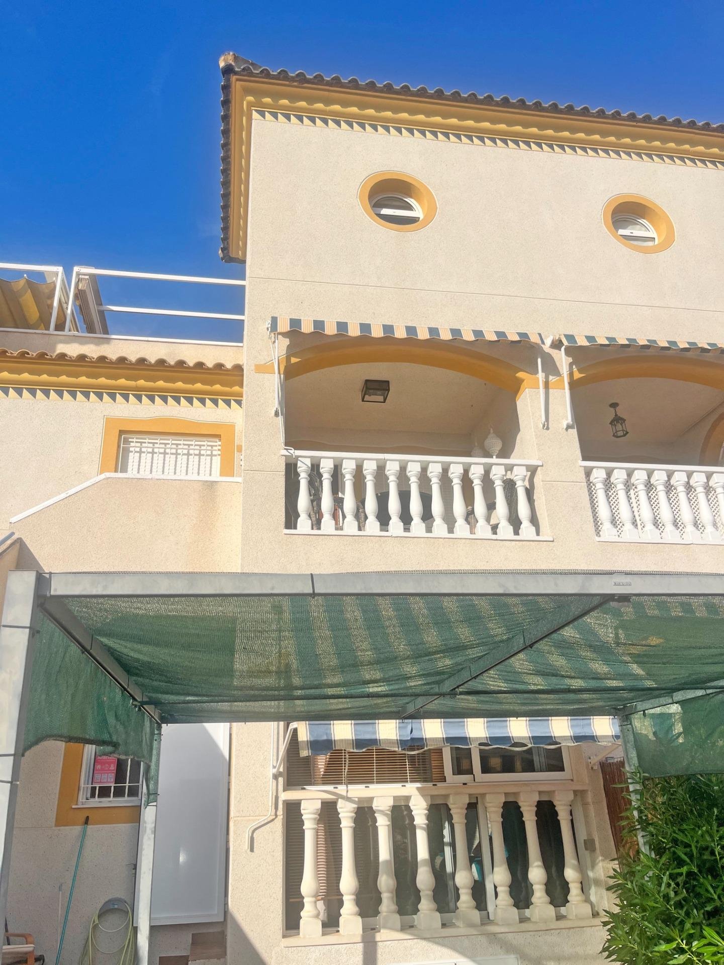 Fachada de casa con toldo