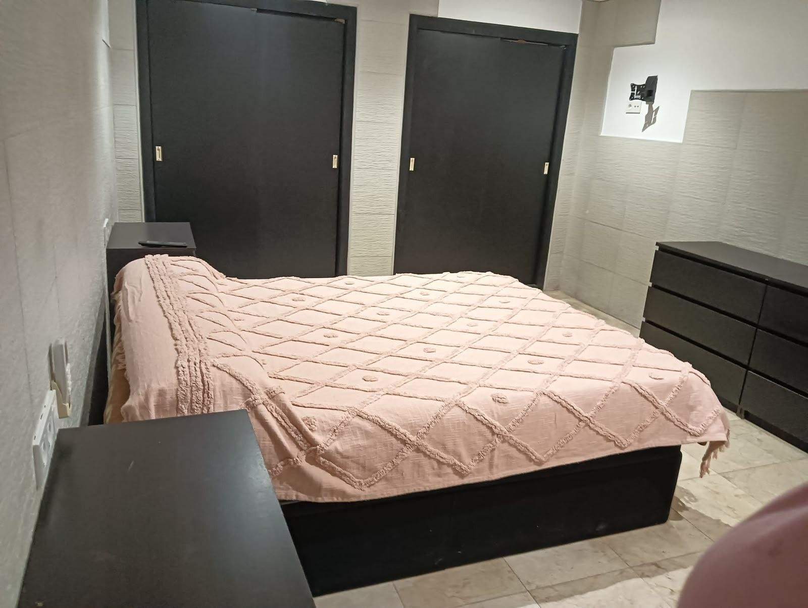 Habitación con cama y muebles oscuros