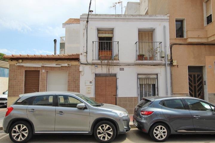 Casa blanca con coches estacionados