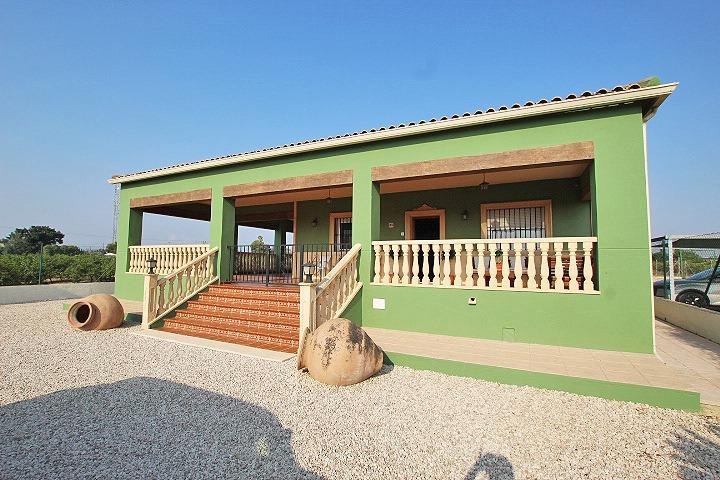 Casa verde con porche y escaleras de acceso