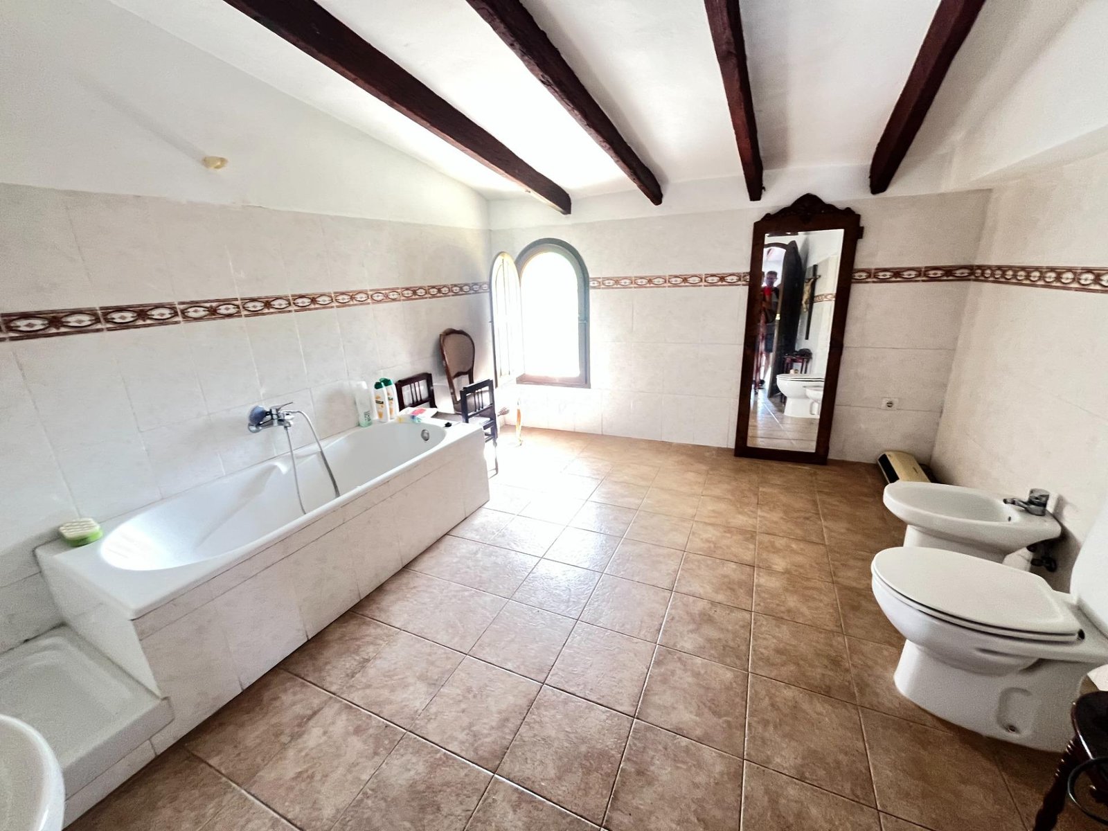 Baño amplio con bañera y espejo