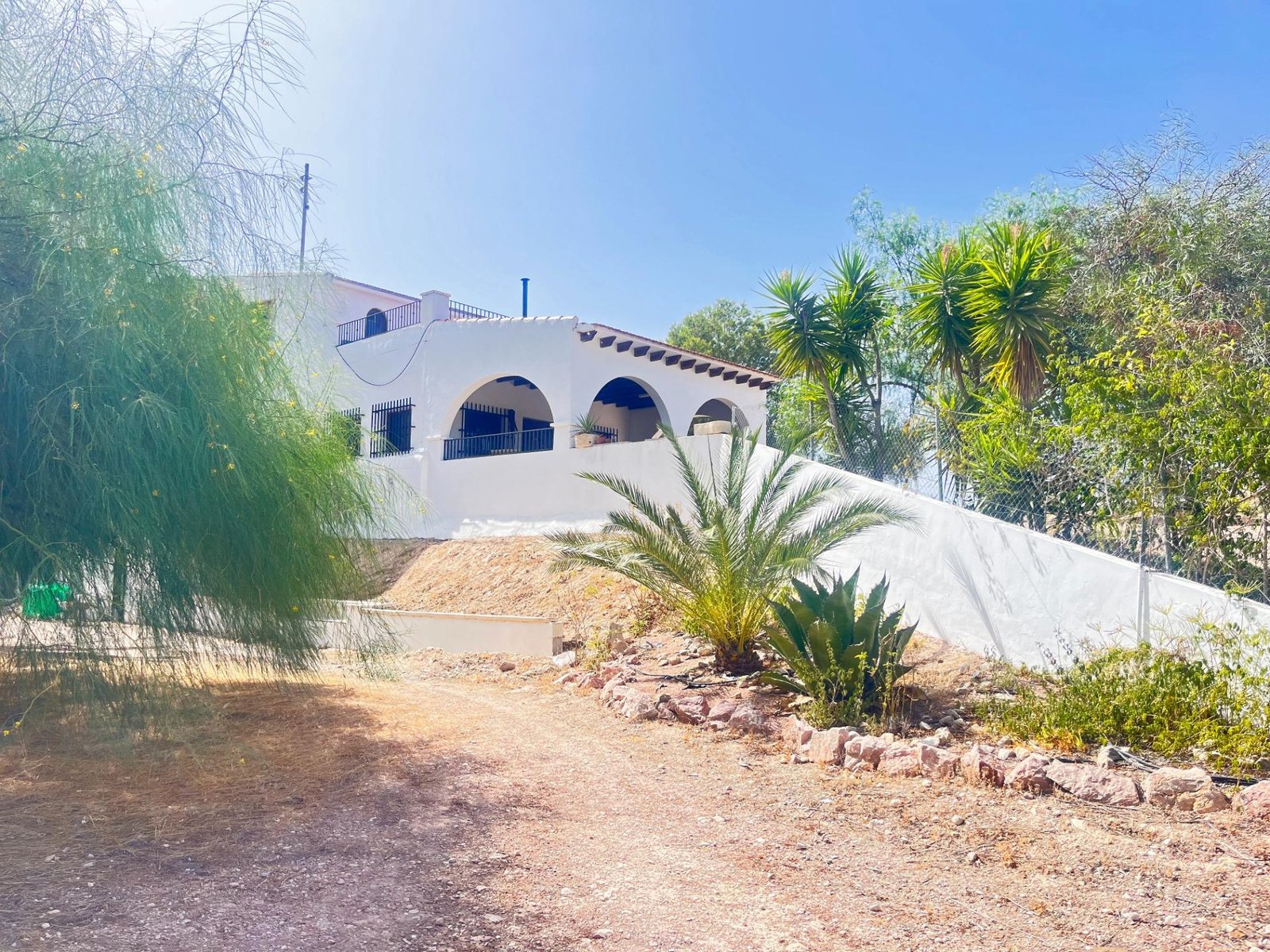 Casa blanca con jardín en el exterior