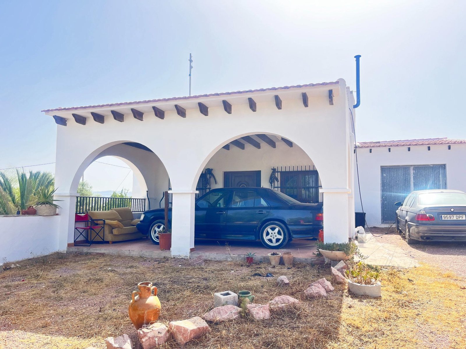 Casa con arcos y coches estacionados