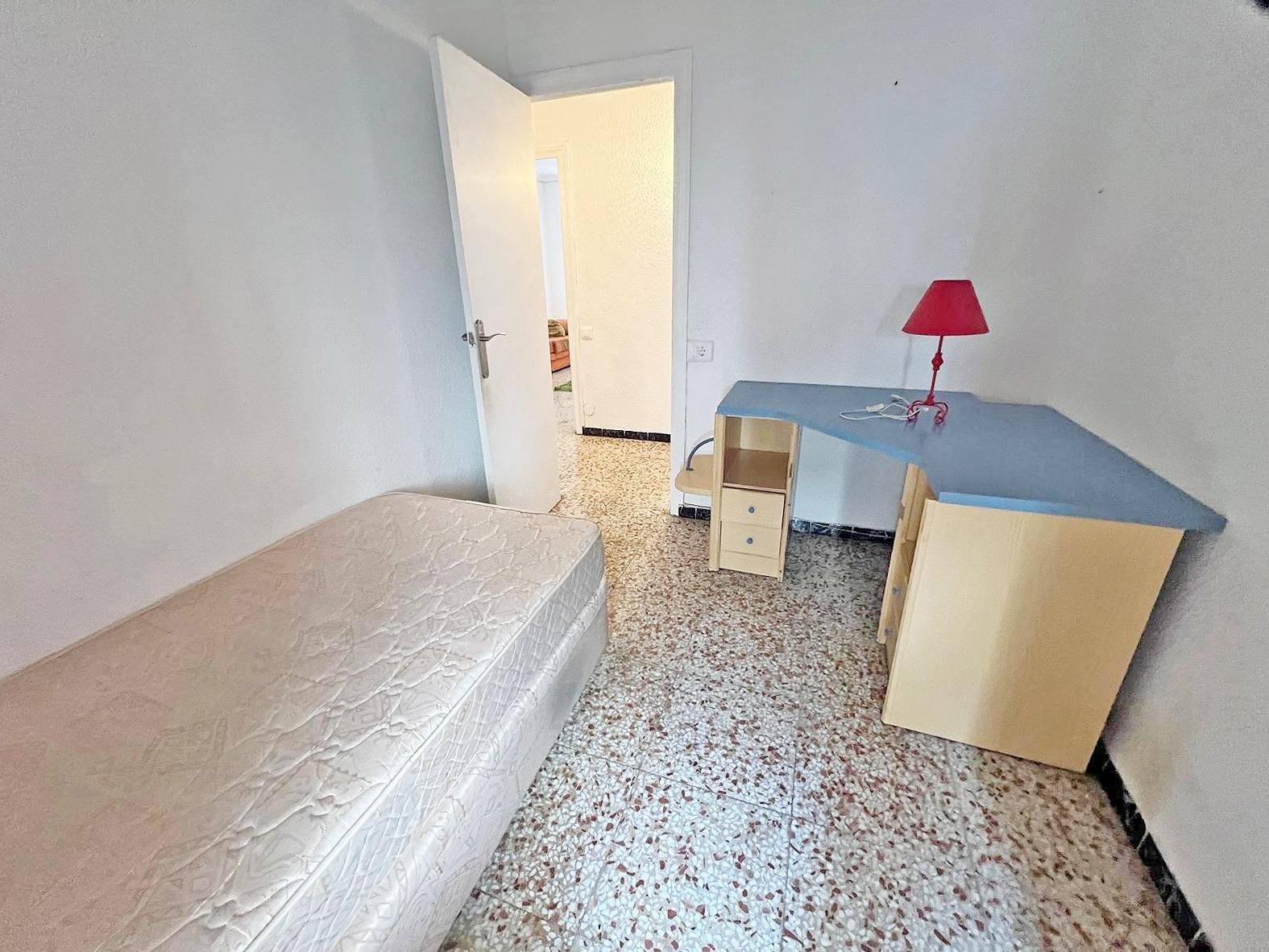 Habitación con escritorio y cama