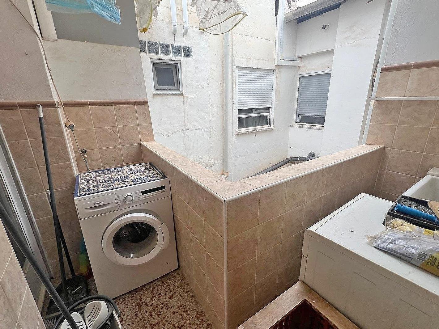Lavadero con lavadora y espacio reducido