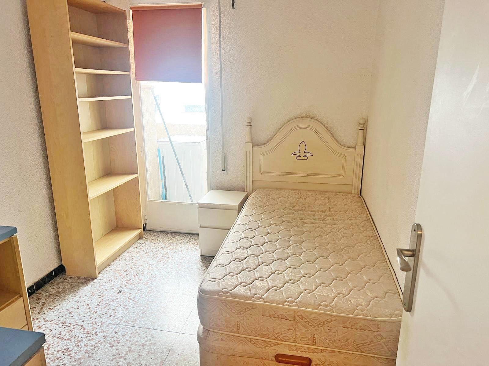 Habitación con cama y estantería