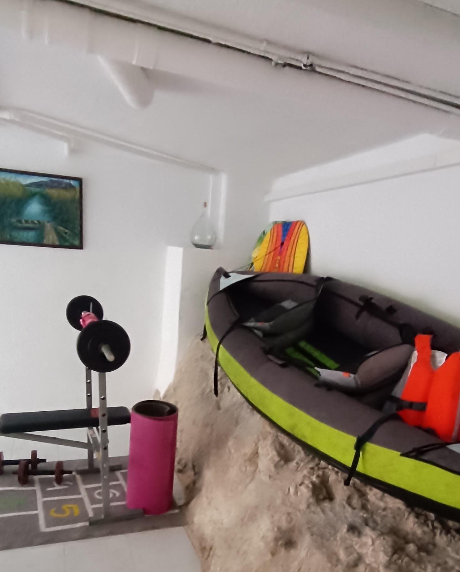 Gimnasio con kayak y equipo de pesas